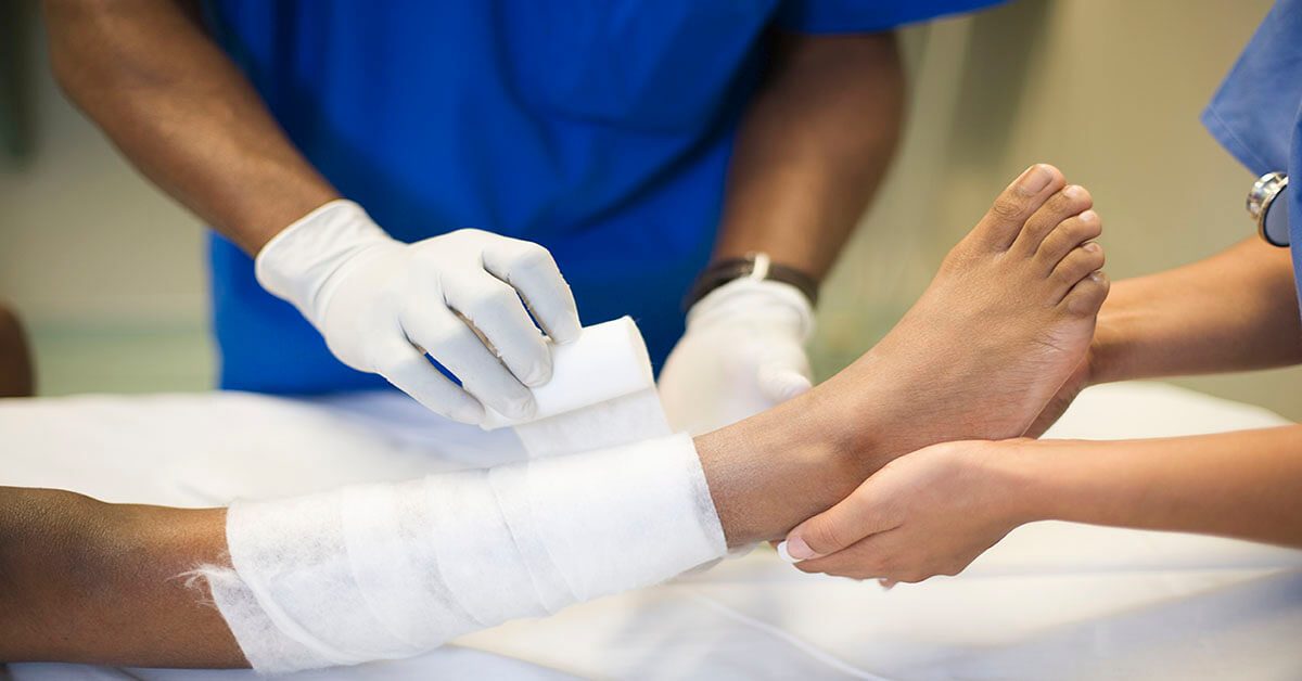 Nurse dressing a patient's foot during wound care